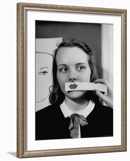 Young Girl Trying to Determine Which Lipstick Color Will Look Right with Her Complexion-Nina Leen-Framed Photographic Print