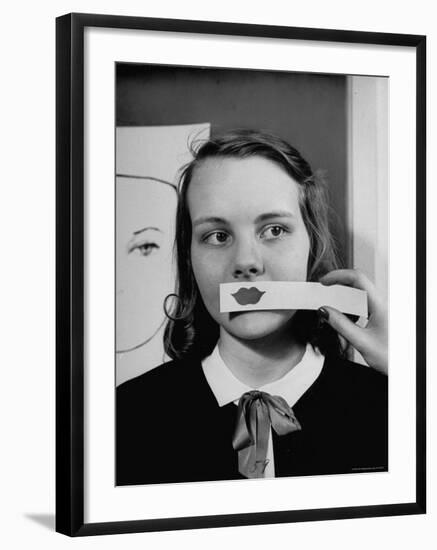 Young Girl Trying to Determine Which Lipstick Color Will Look Right with Her Complexion-Nina Leen-Framed Photographic Print