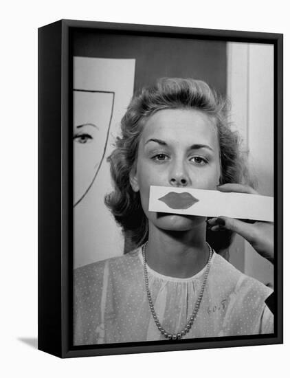 Young Girl Trying to Determine Which Lipstick Color Will Look Right with Her Complextion-Nina Leen-Framed Premier Image Canvas