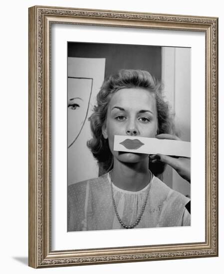 Young Girl Trying to Determine Which Lipstick Color Will Look Right with Her Complextion-Nina Leen-Framed Photographic Print