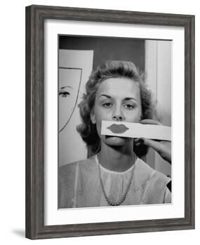 Young Girl Trying to Determine Which Lipstick Color Will Look Right with Her Complextion-Nina Leen-Framed Photographic Print
