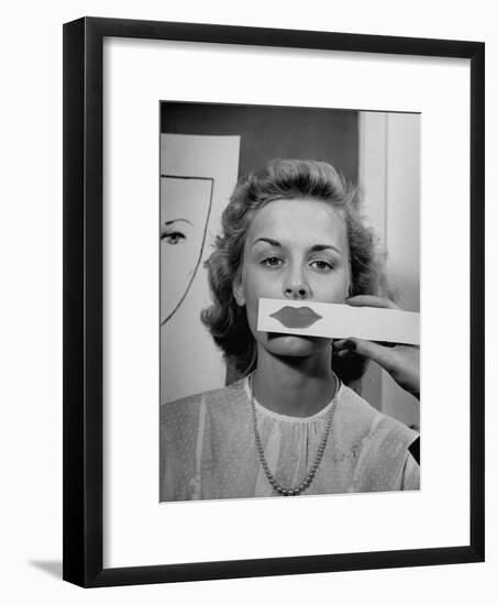 Young Girl Trying to Determine Which Lipstick Color Will Look Right with Her Complextion-Nina Leen-Framed Photographic Print