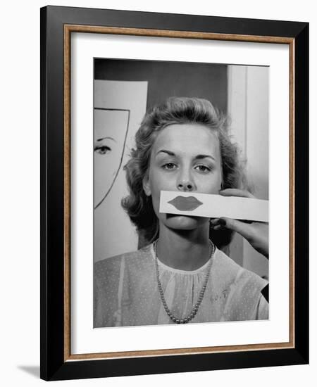 Young Girl Trying to Determine Which Lipstick Color Will Look Right with Her Complextion-Nina Leen-Framed Photographic Print