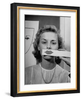 Young Girl Trying to Determine Which Lipstick Color Will Look Right with Her Complextion-Nina Leen-Framed Photographic Print