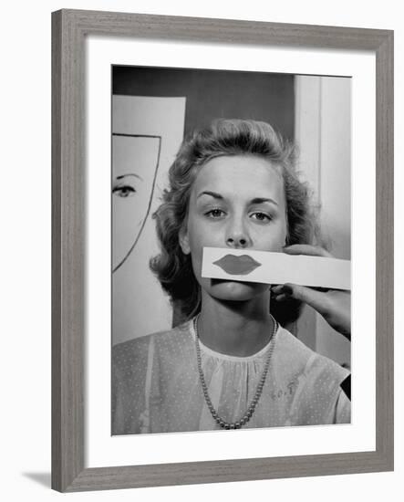 Young Girl Trying to Determine Which Lipstick Color Will Look Right with Her Complextion-Nina Leen-Framed Photographic Print