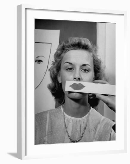 Young Girl Trying to Determine Which Lipstick Color Will Look Right with Her Complextion-Nina Leen-Framed Photographic Print