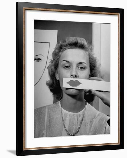 Young Girl Trying to Determine Which Lipstick Color Will Look Right with Her Complextion-Nina Leen-Framed Photographic Print