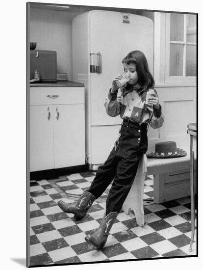 Young Girl Wearing Cowgirl Outfit Drinking Milk and Eating Sandwich in Kitchen-Nina Leen-Mounted Photographic Print