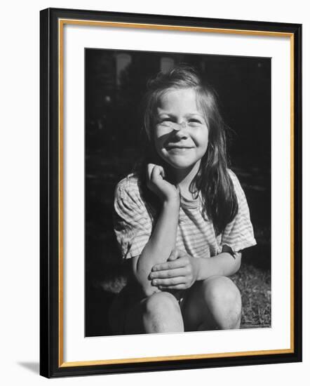 Young Girl with Long Hair and Raggedy Shirt, Smiling, Wearing Seed Pod on Nose-Ralph Morse-Framed Photographic Print