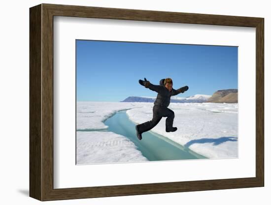 Young Inuit Boy Jumping over a Crack on Ice Floe, Ellesmere Island, Nanavut, Canada, June 2012-Eric Baccega-Framed Photographic Print