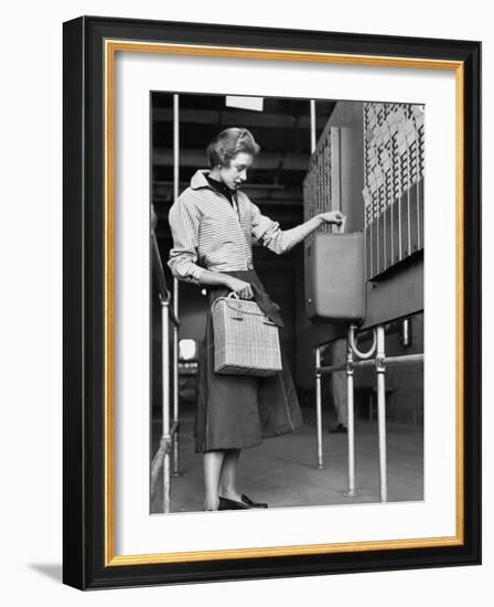 Young Lady Modeling New Line of Clothing While Getting Her Time Card Punched-Yale Joel-Framed Photographic Print