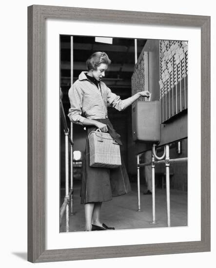 Young Lady Modeling New Line of Clothing While Getting Her Time Card Punched-Yale Joel-Framed Photographic Print