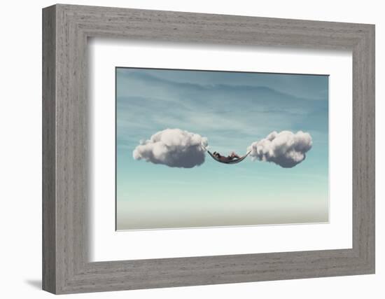 Young Man Relaxes in a Hammock between Two Clouds.-Orla-Framed Photographic Print