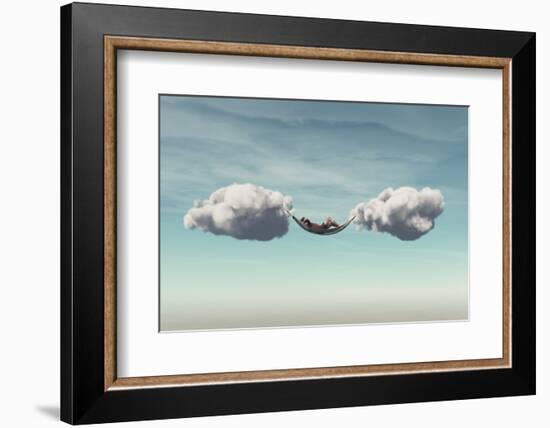 Young Man Relaxes in a Hammock between Two Clouds.-Orla-Framed Photographic Print