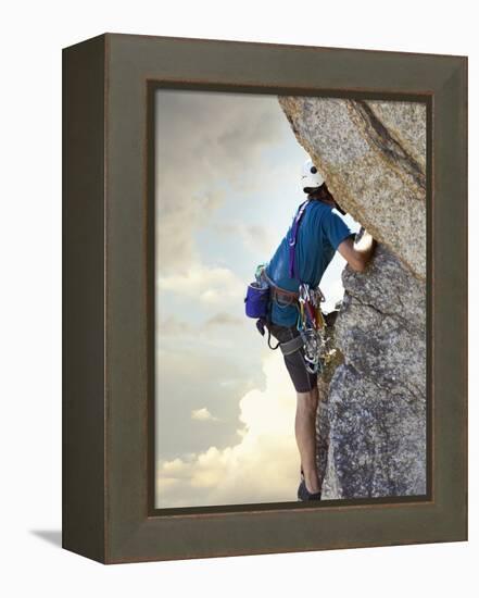 Young man rock climbing up a vertical cliff-null-Framed Premier Image Canvas