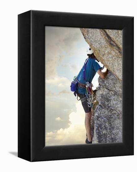 Young man rock climbing up a vertical cliff-null-Framed Premier Image Canvas