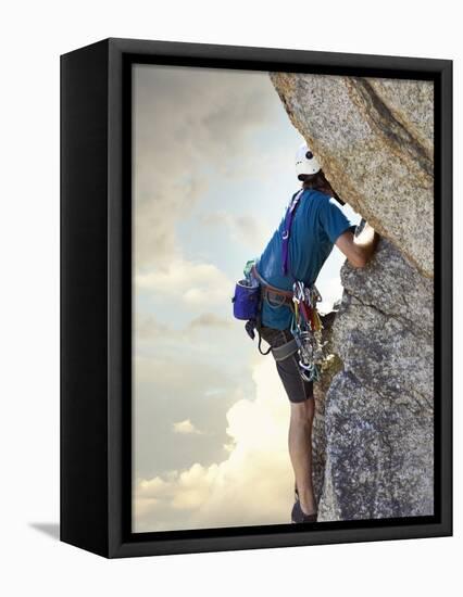 Young man rock climbing up a vertical cliff-null-Framed Premier Image Canvas