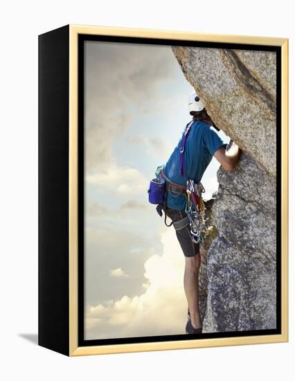 Young man rock climbing up a vertical cliff-null-Framed Premier Image Canvas