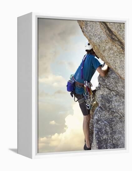 Young man rock climbing up a vertical cliff-null-Framed Premier Image Canvas