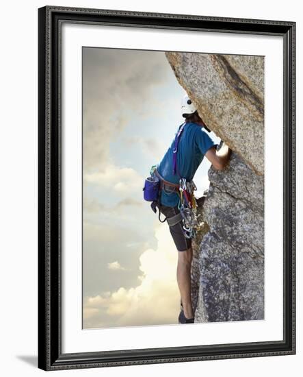 Young man rock climbing up a vertical cliff-null-Framed Photographic Print