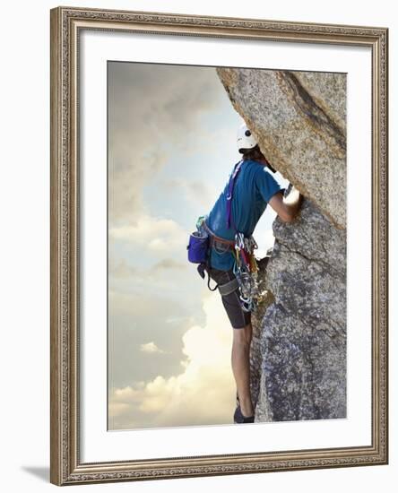 Young man rock climbing up a vertical cliff-null-Framed Photographic Print