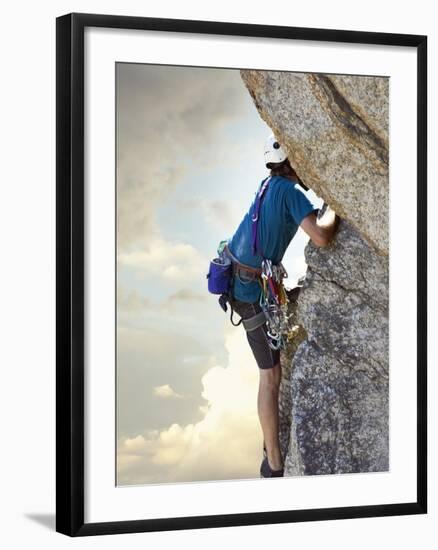 Young man rock climbing up a vertical cliff-null-Framed Photographic Print