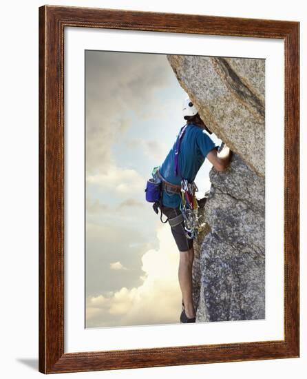 Young man rock climbing up a vertical cliff-null-Framed Photographic Print