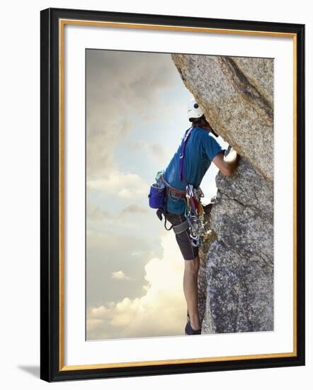 Young man rock climbing up a vertical cliff-null-Framed Photographic Print