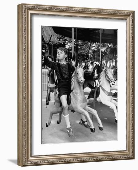 Young Turkish Prodigy Hassan Kaptan Riding a Merry Go Round-Gordon Parks-Framed Photographic Print