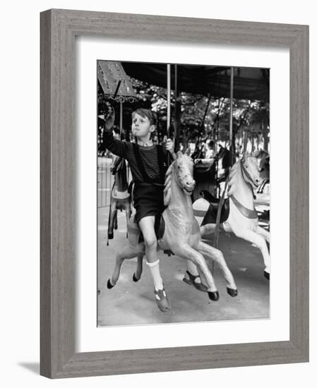 Young Turkish Prodigy Hassan Kaptan Riding a Merry Go Round-Gordon Parks-Framed Photographic Print