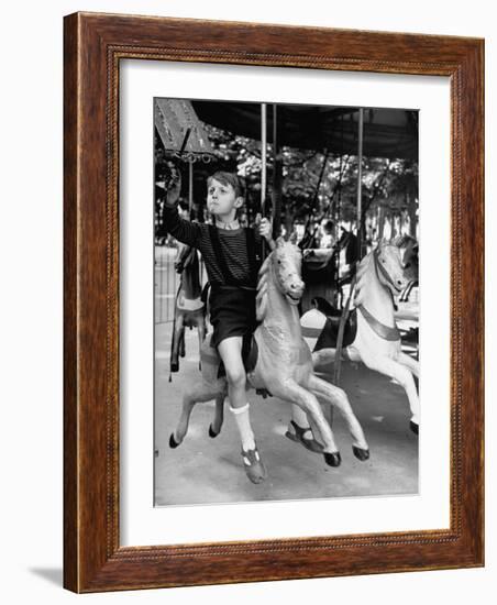 Young Turkish Prodigy Hassan Kaptan Riding a Merry Go Round-Gordon Parks-Framed Photographic Print