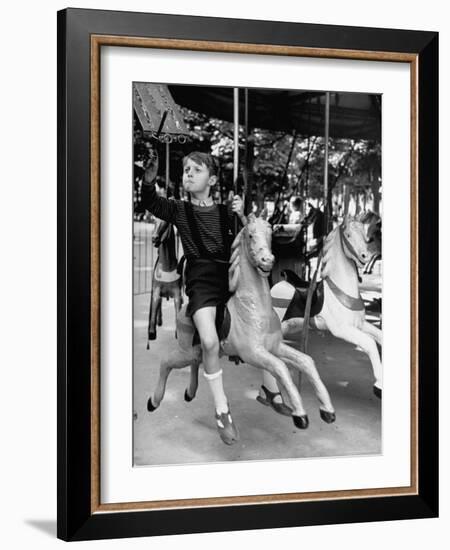 Young Turkish Prodigy Hassan Kaptan Riding a Merry Go Round-Gordon Parks-Framed Photographic Print