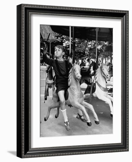 Young Turkish Prodigy Hassan Kaptan Riding a Merry Go Round-Gordon Parks-Framed Photographic Print