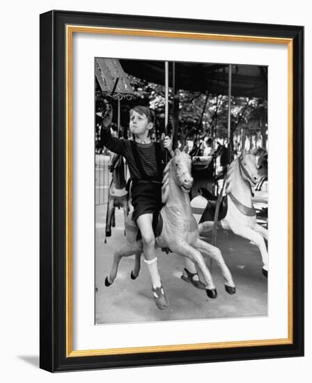 Young Turkish Prodigy Hassan Kaptan Riding a Merry Go Round-Gordon Parks-Framed Photographic Print