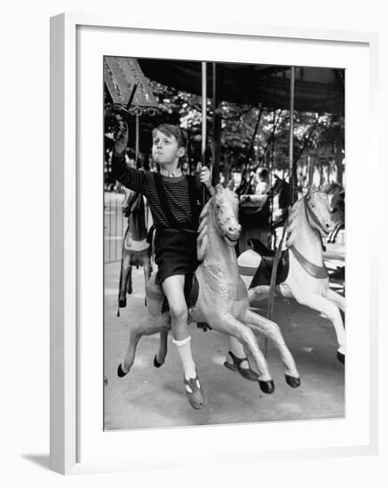 Young Turkish Prodigy Hassan Kaptan Riding a Merry Go Round-Gordon Parks-Framed Photographic Print