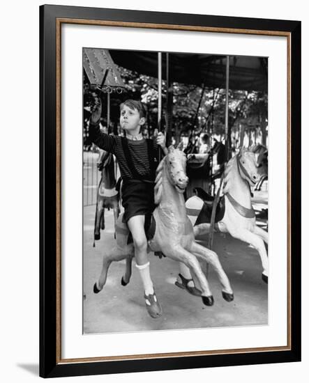 Young Turkish Prodigy Hassan Kaptan Riding a Merry Go Round-Gordon Parks-Framed Photographic Print