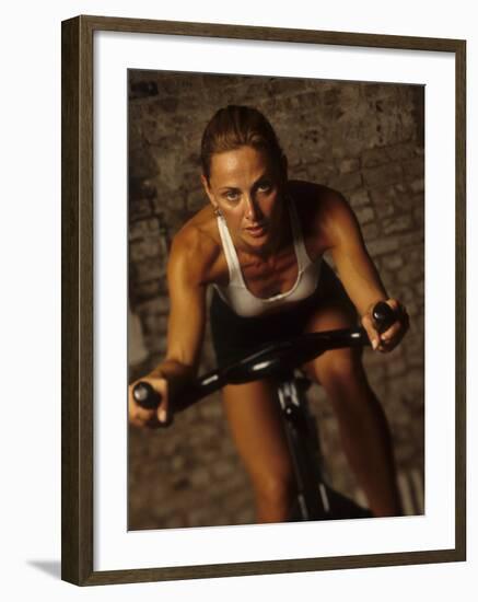 Young Woman Exercising on a Stationary Bike-null-Framed Photographic Print