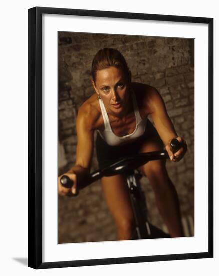 Young Woman Exercising on a Stationary Bike-null-Framed Photographic Print