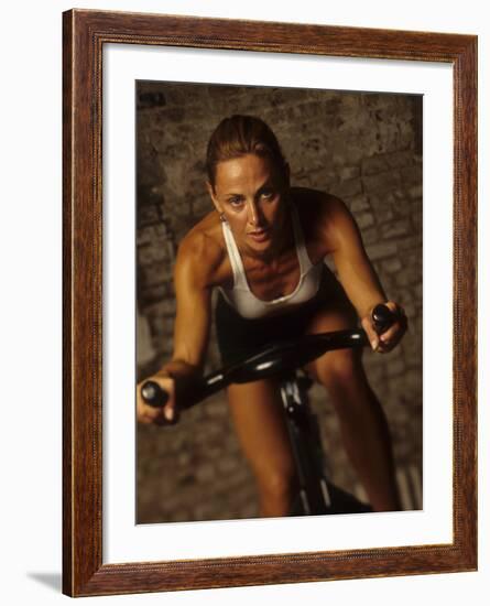 Young Woman Exercising on a Stationary Bike-null-Framed Photographic Print