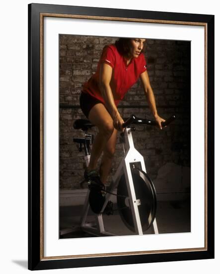 Young Woman Exercising on a Stationary Bike-null-Framed Photographic Print