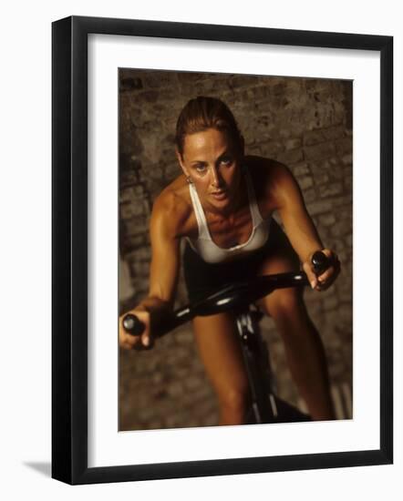 Young Woman Exercising on a Stationary Bike-null-Framed Photographic Print