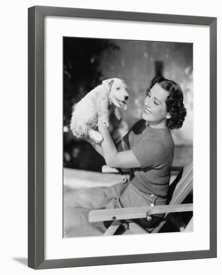 Young Woman Holding Up Her Puppy and Smiling-null-Framed Photo