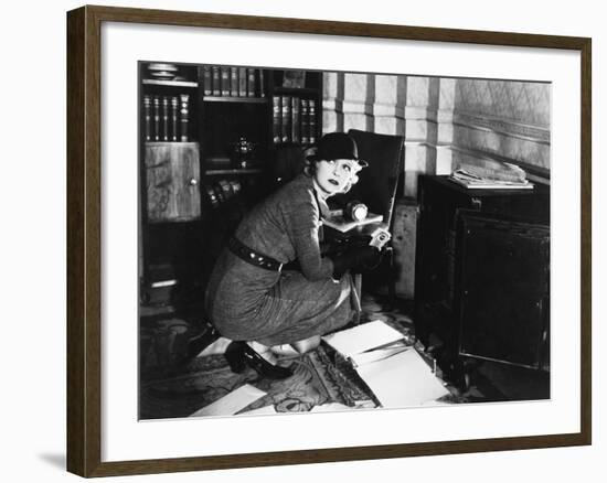 Young Woman in an Office Next to a Safe, Looking over Her Shoulder-null-Framed Photo