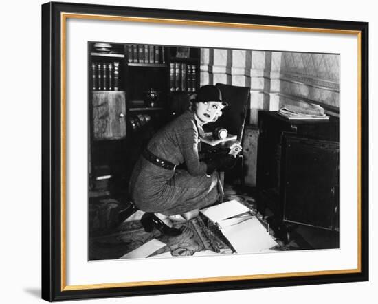 Young Woman in an Office Next to a Safe, Looking over Her Shoulder-null-Framed Photo