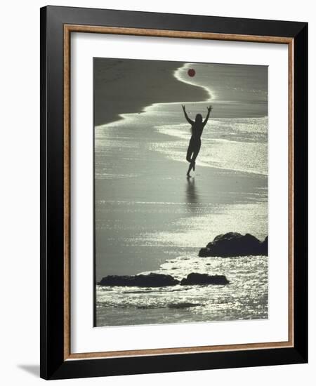 Young Woman in Silhouette Running Along Beach at Twilight Throwing Beach Ball Up in the Air-Co Rentmeester-Framed Photographic Print