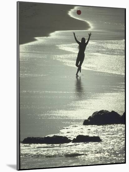 Young Woman in Silhouette Running Along Beach at Twilight Throwing Beach Ball Up in the Air-Co Rentmeester-Mounted Photographic Print