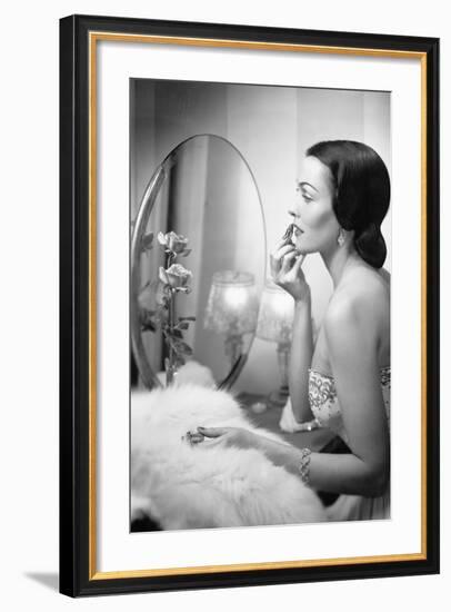 Young Woman Looking into a Mirror and Putting on Make Up-null-Framed Photo