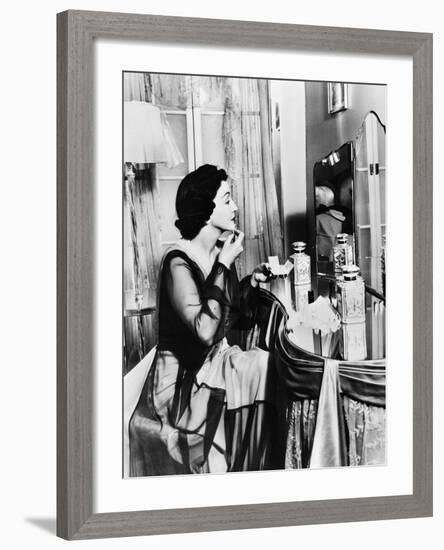 Young Woman Looking into a Mirror and Putting on Make Up-null-Framed Photo