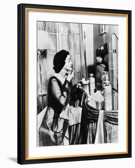 Young Woman Looking into a Mirror and Putting on Make Up-null-Framed Photo