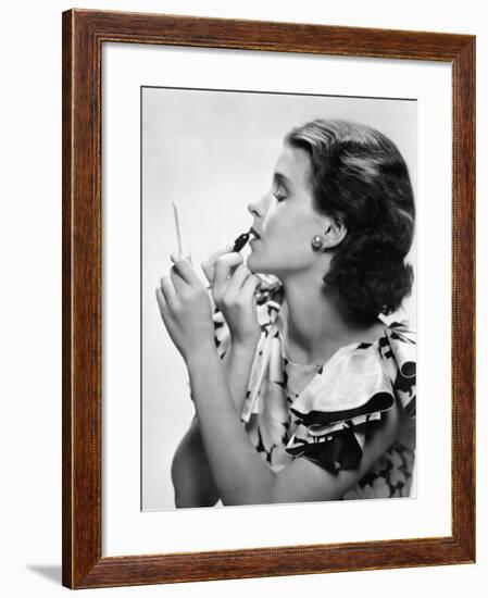 Young Woman Looking into a Mirror and Putting on Make Up-null-Framed Photo